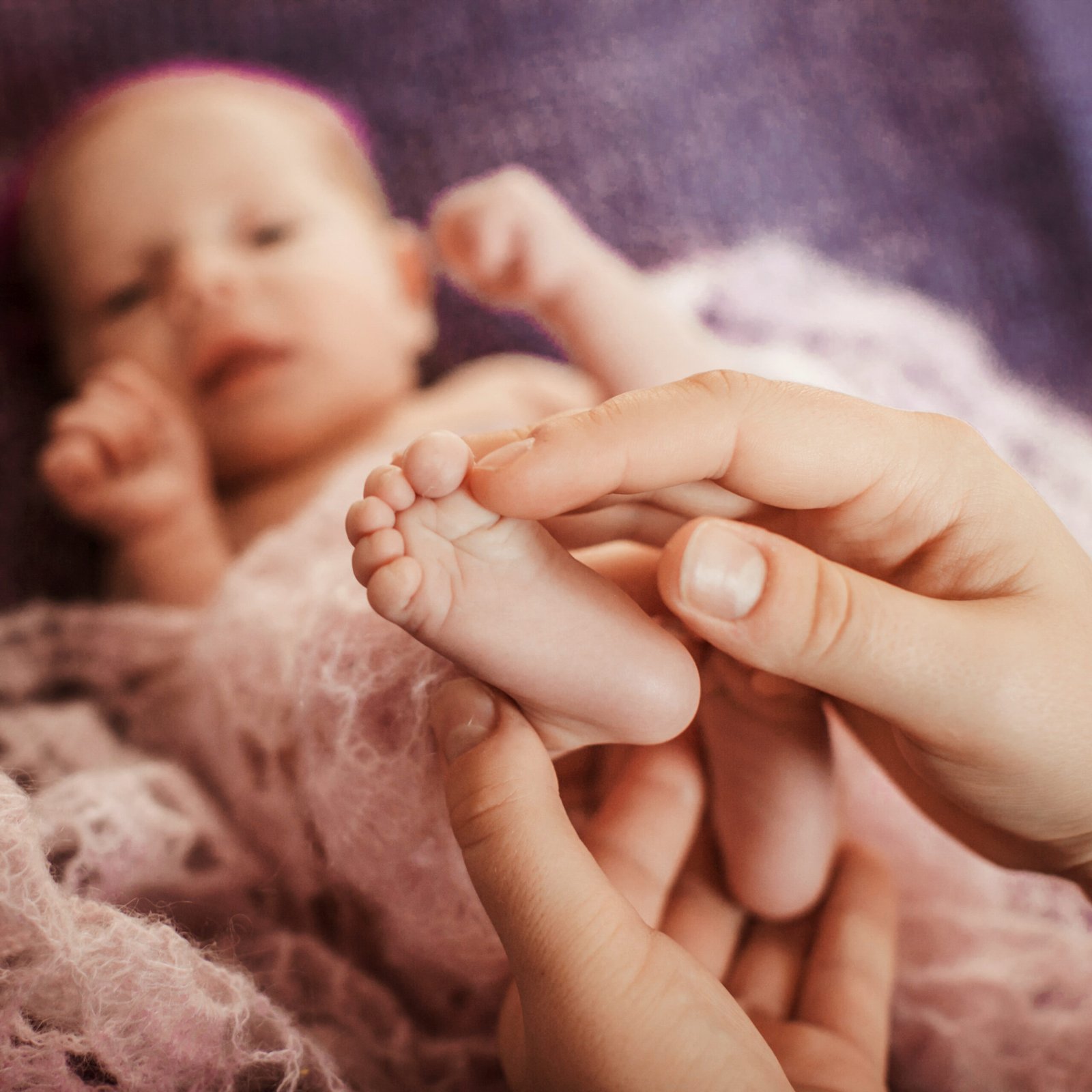 Father gently touching his baby's feet